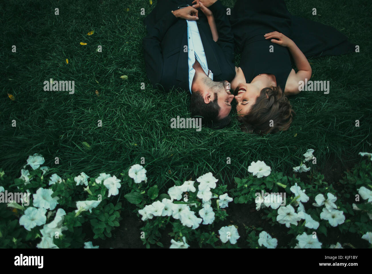 Coppia caucasica posa in erba ridere Foto Stock
