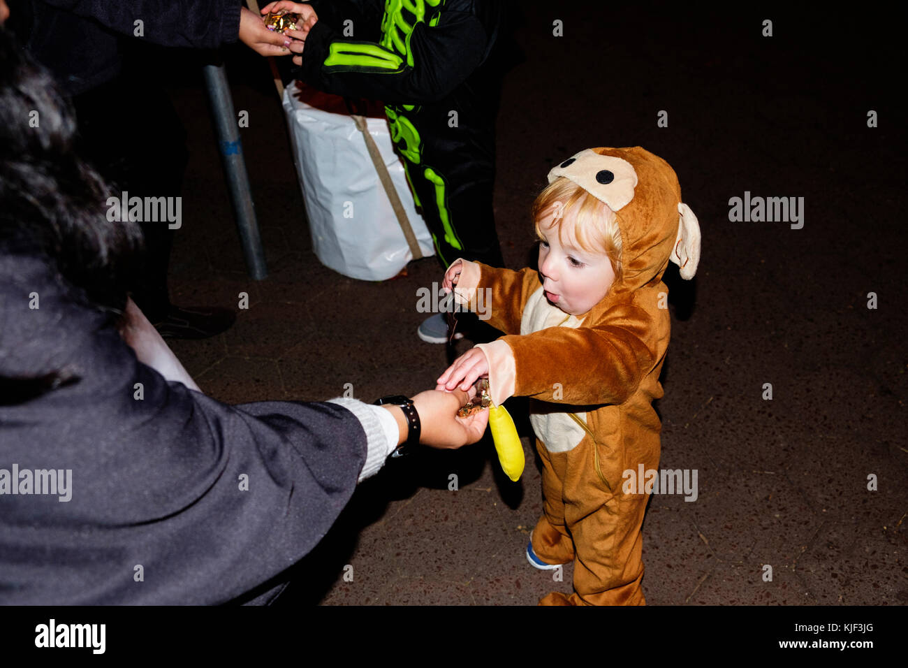 Donna che tratta di Caucasian ragazzo che indossa un costume da orso Foto Stock