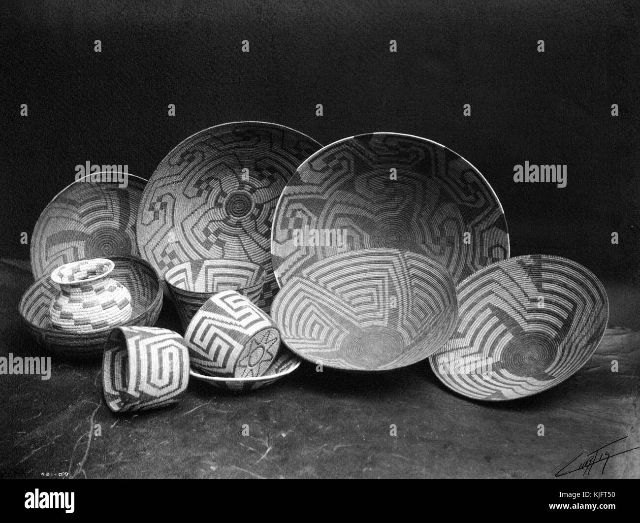 Una fotografia di una collezione di cesti di Pima, i cesti sono tessuti con materiali provenienti da piante e alberi diversi, i Pima utilizzano tipicamente una struttura labirintica per un disegno che riflette la storia di una guida creatrice e come allegoria per le scelte fatte nella vita, i Pima risiedono principalmente nell'Arizona centrale e meridionale, nel 1907. Dalla New York Public Library. Foto Stock