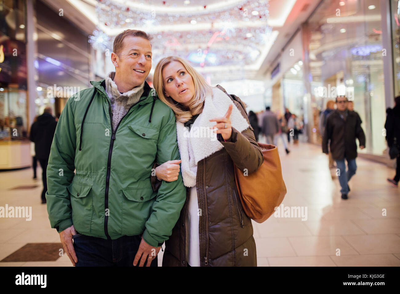 Una coppia che cerca di trovare qualcosa di nuovo per i regali di Natale in un centro commerciale. Foto Stock