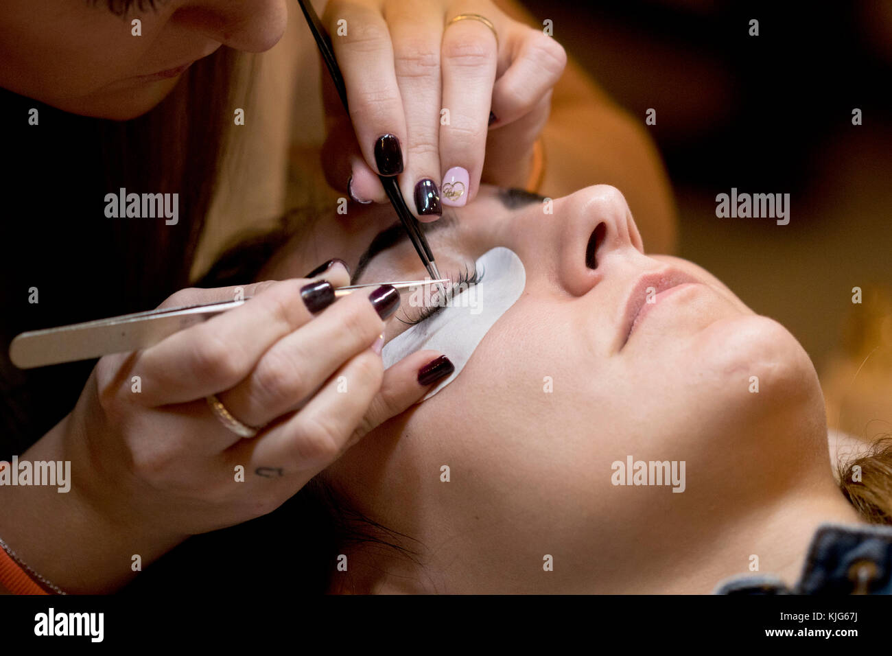 Immagine closeup di un professionista che aggiunge estensioni eyelash a un cliente in Salon Look Madrid 2017. Foto Stock