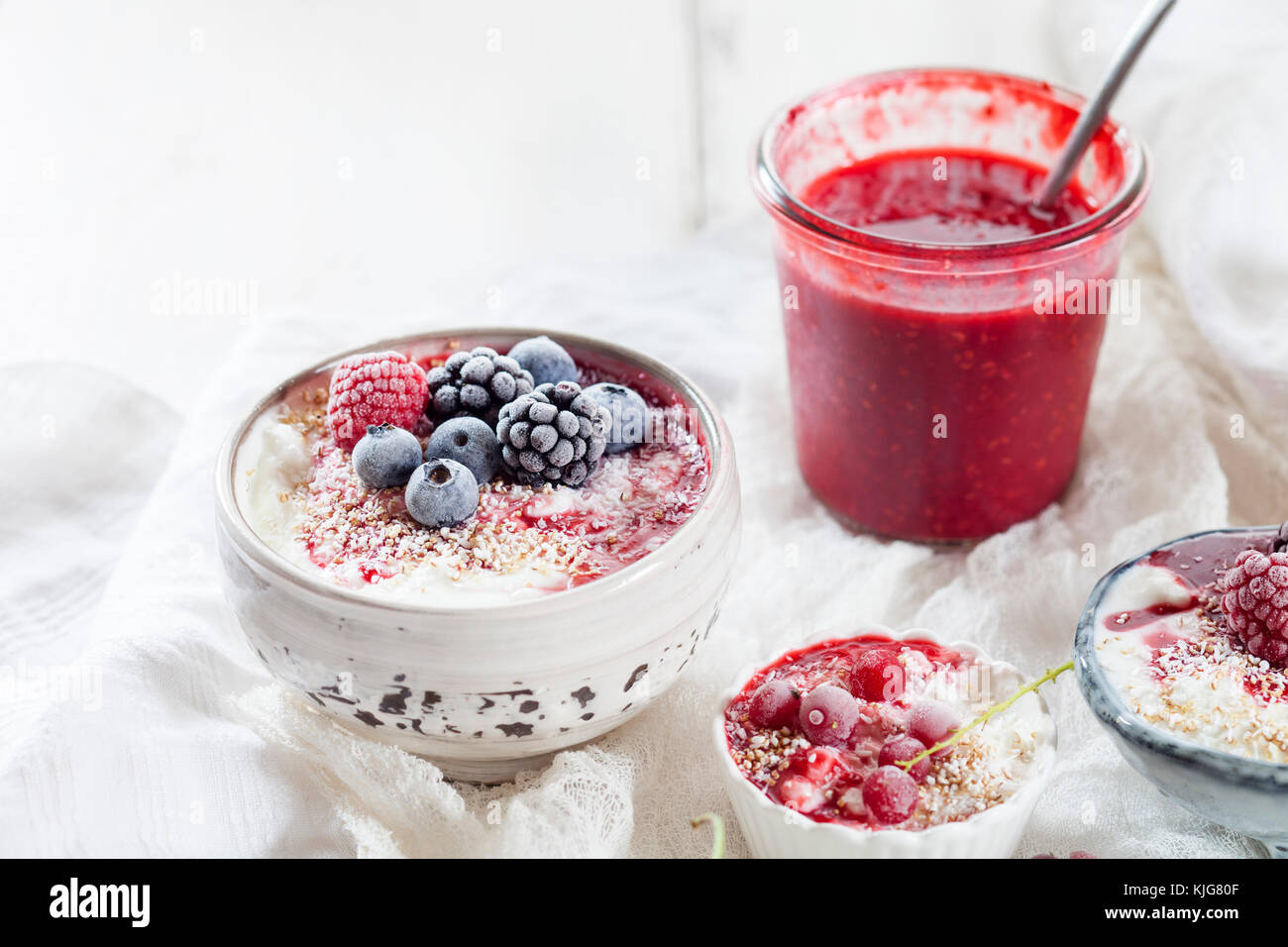 Ciotola di yogurt naturale con salsa di lamponi congelati e di frutta Foto Stock