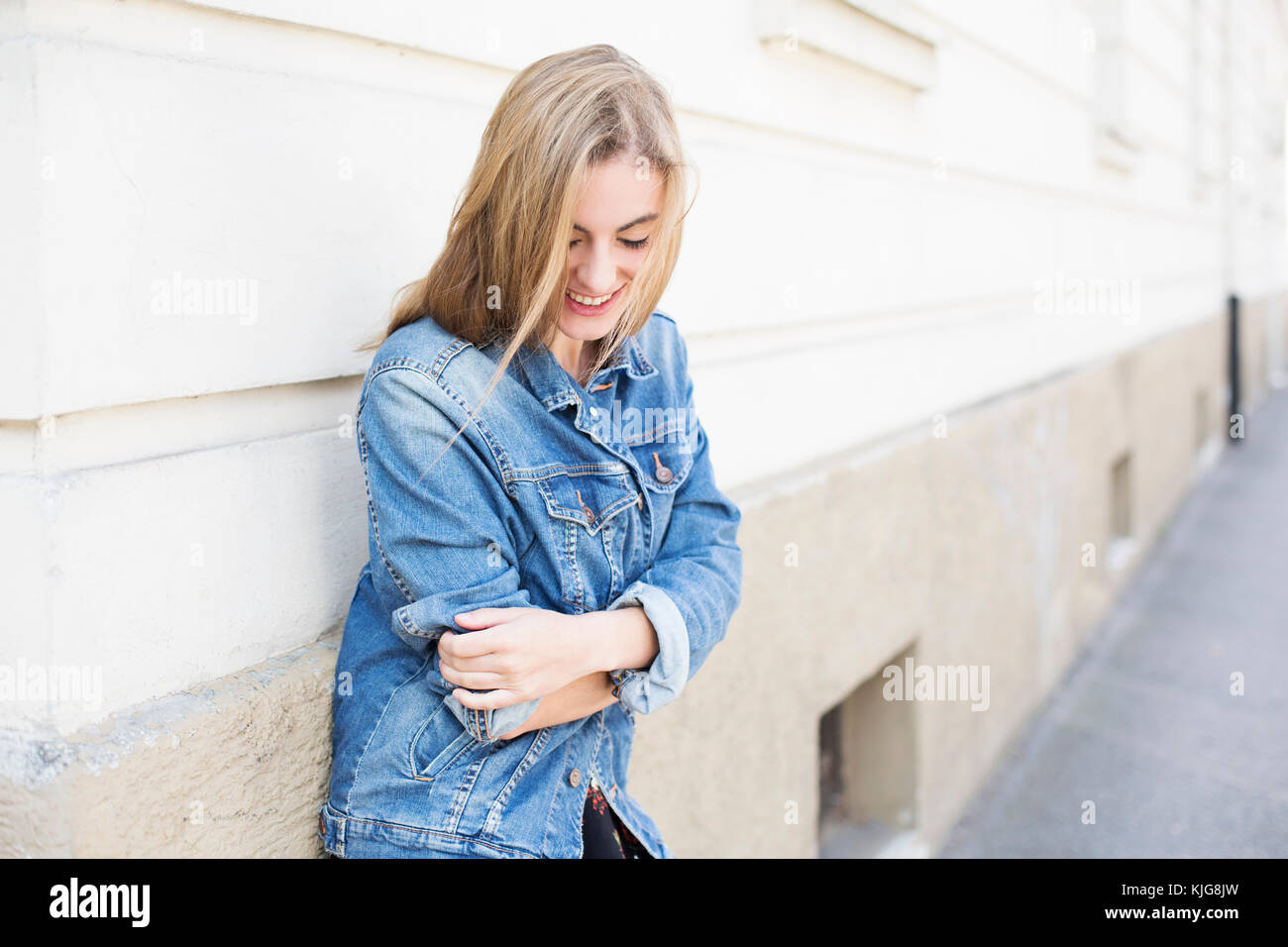 Ritratto di sorridente giovane donna di fronte della facciata della casa Foto Stock