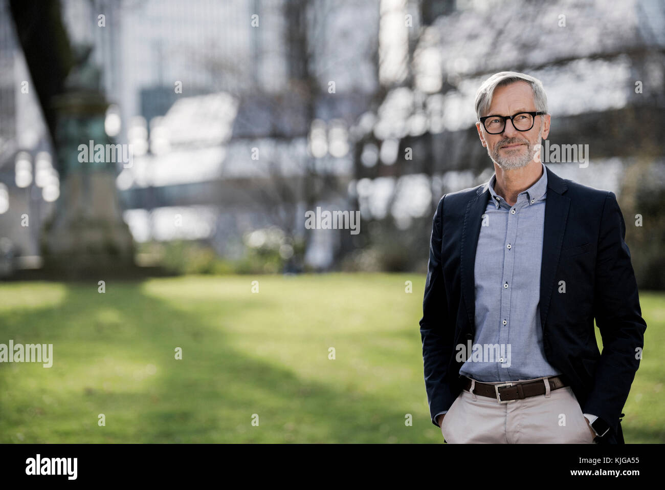 Grey-haired imprenditore nel parco della città Foto Stock