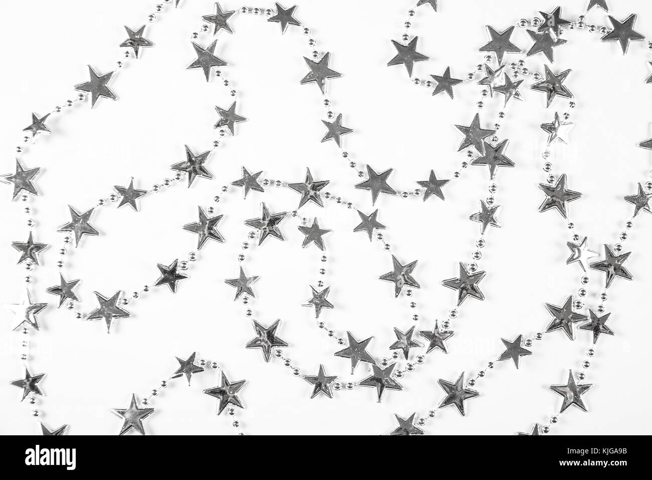 Sfondo di natale con argento stelle decorazioni su bianco. semplice composizione di natale con spazio di copia Foto Stock