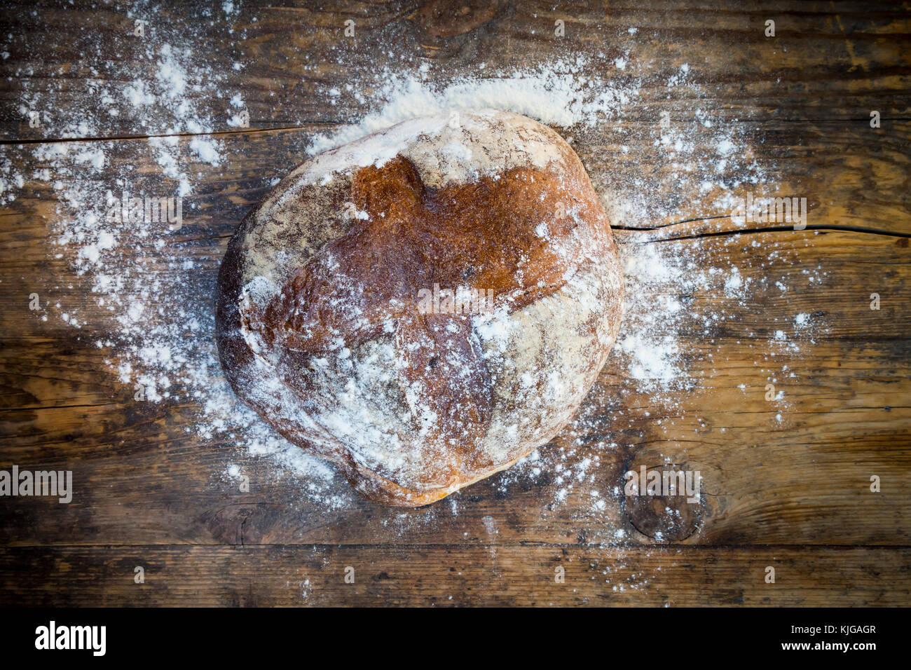Pane di grano in polvere con la farina su legno scuro Foto Stock