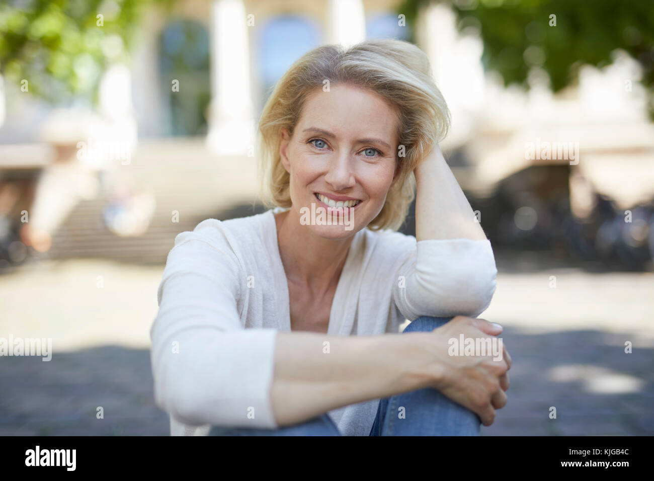 Ritratto di sorridere donna bionda con in mano i suoi capelli Foto Stock