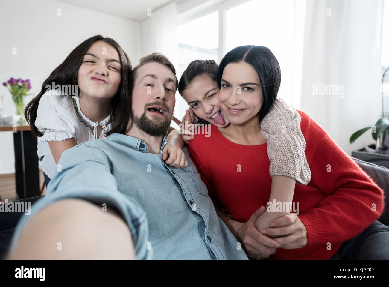 Genitori e figlie gemelle ingannare intorno prendendo un selfie Foto Stock