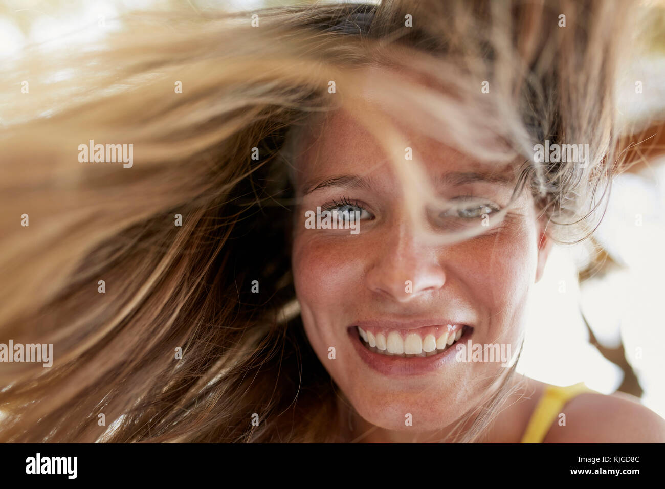 Ritratto di ridere giovane donna con i capelli di soffiatura Foto Stock