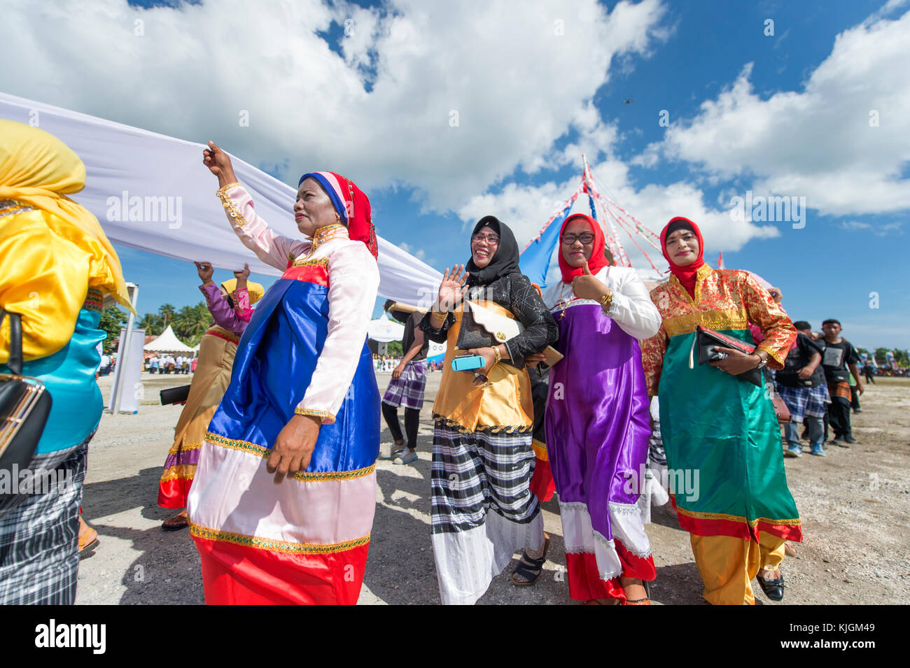 Tasto donne parata e eseguire la danza con colorati costumi tradizionali durante il wakatobi. wave festival. Foto Stock