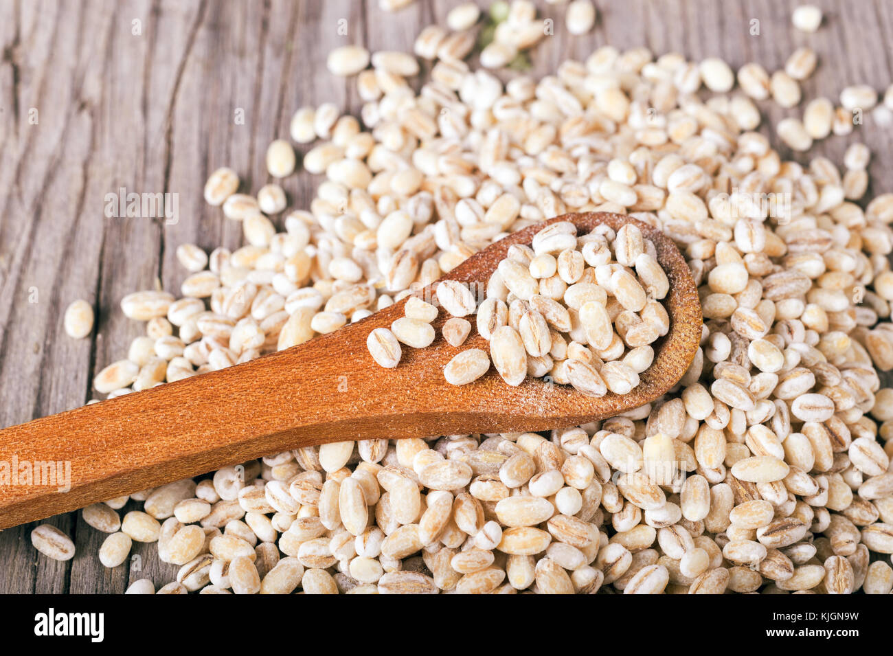 Orzo perlato grani in cucchiaio di legno Foto Stock