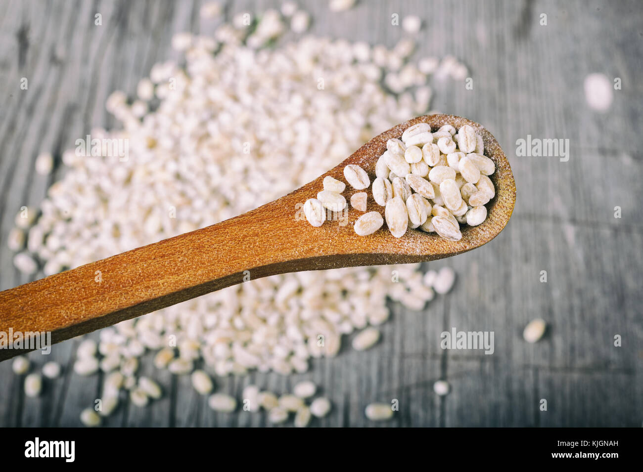 Orzo perlato grani in cucchiaio di legno Foto Stock