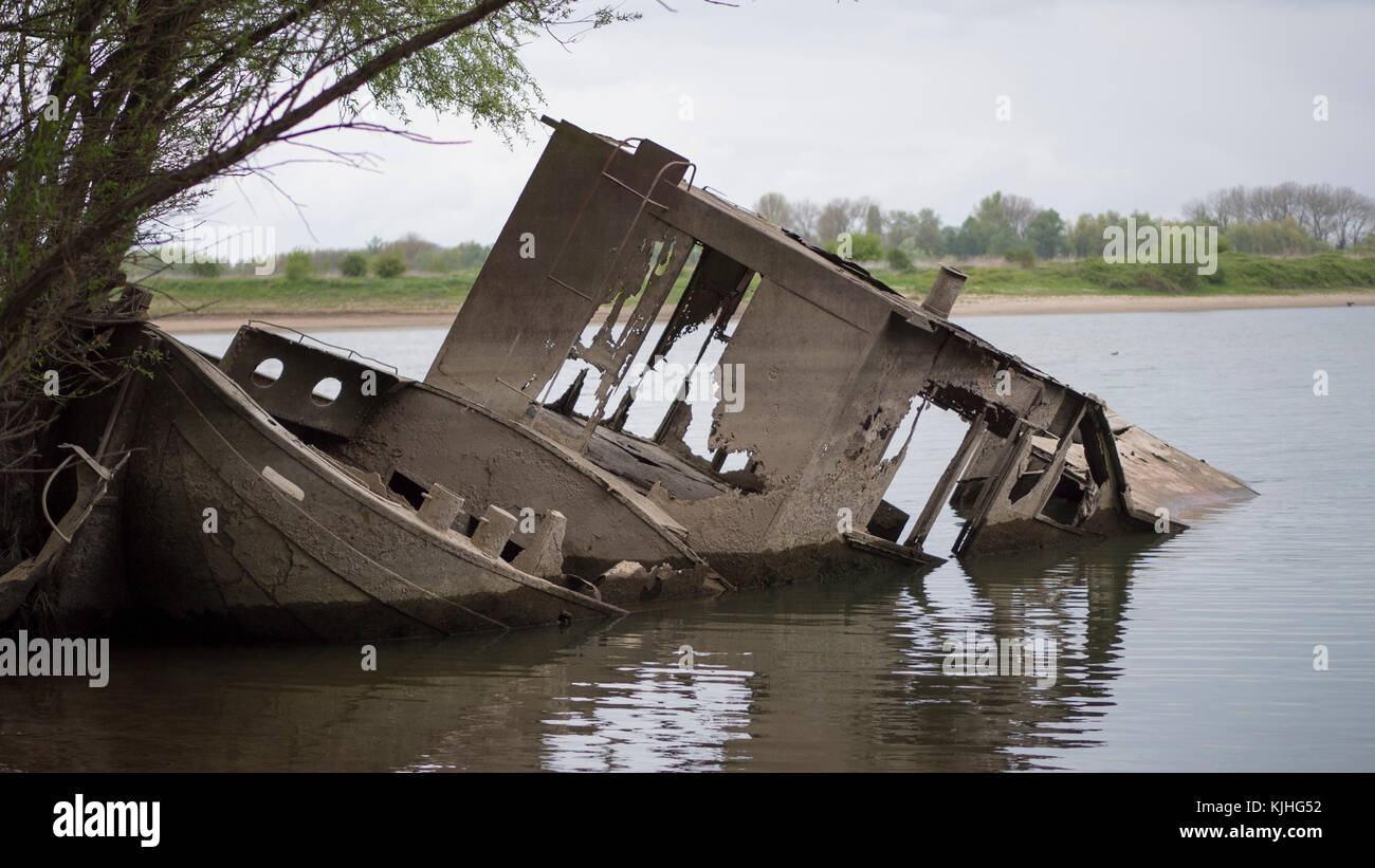 Barca affondata sul letto del fiume Foto Stock