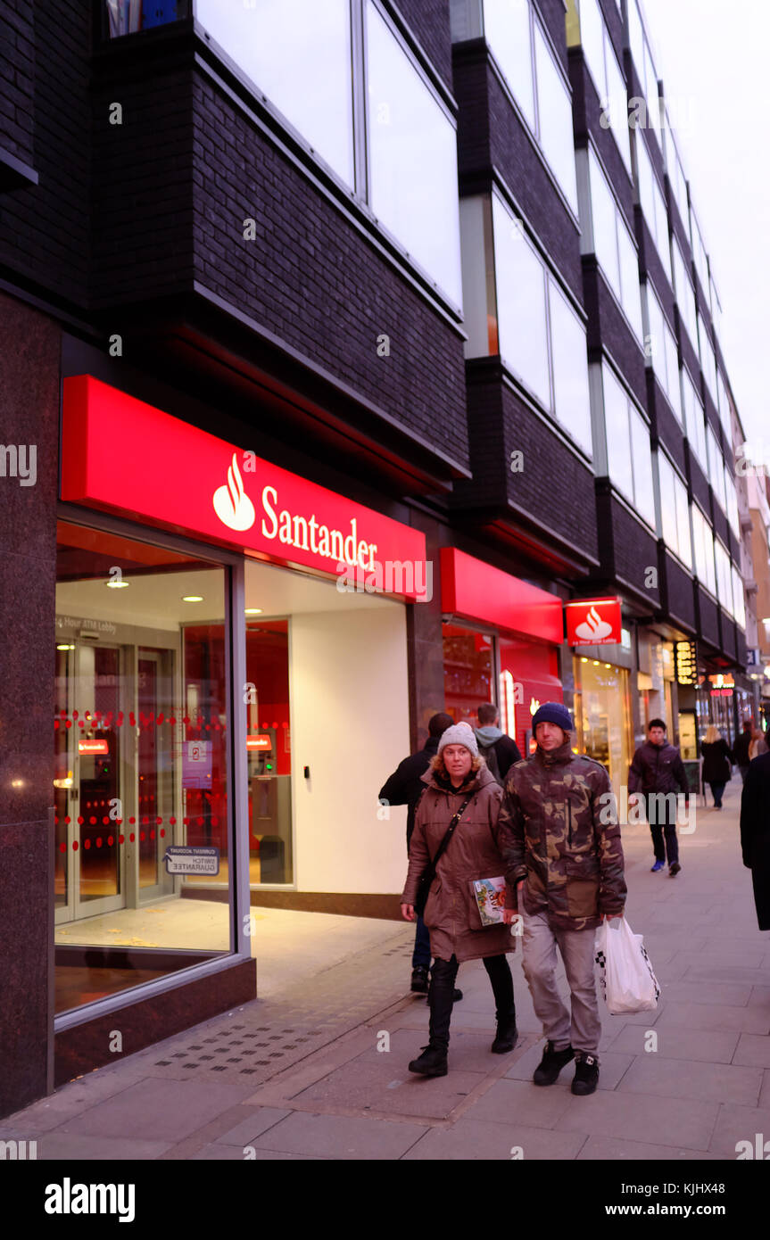 Banca Santander con gente camminare passato su Tottenham Court Road, Londra, Inghilterra Foto Stock