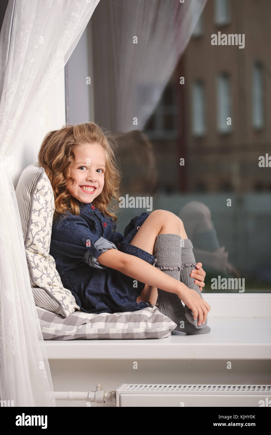 Bambina sul davanzale di casa Foto Stock