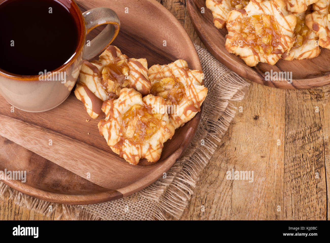 Apple caramello i cookie su un piatto di legno con tazza di caffè Foto Stock