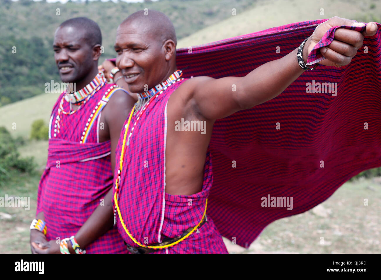 Masai uomini che indossano colorati abiti tradizionali. Masai Mara Game Reserve. Kenya. Foto Stock
