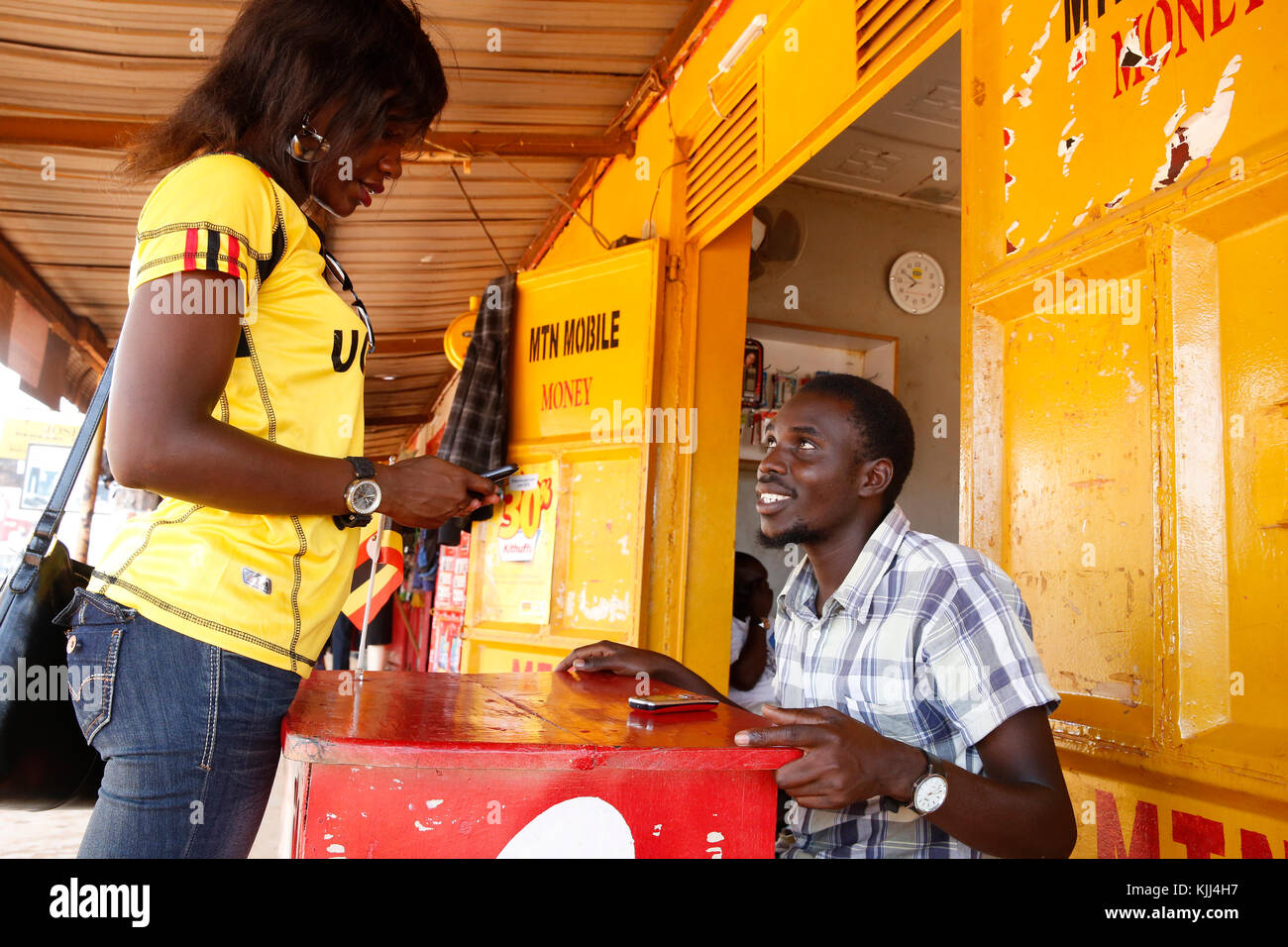 Donna ugandese di inviare denaro tramite il telefono cellulare. Uganda Foto Stock