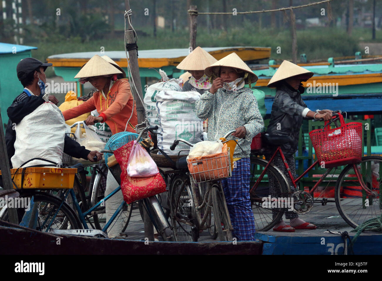 Le donne nel cappello conico con merci per la vendita sul mercato dei prodotti freschi. Hoi An. Il Vietnam. Foto Stock