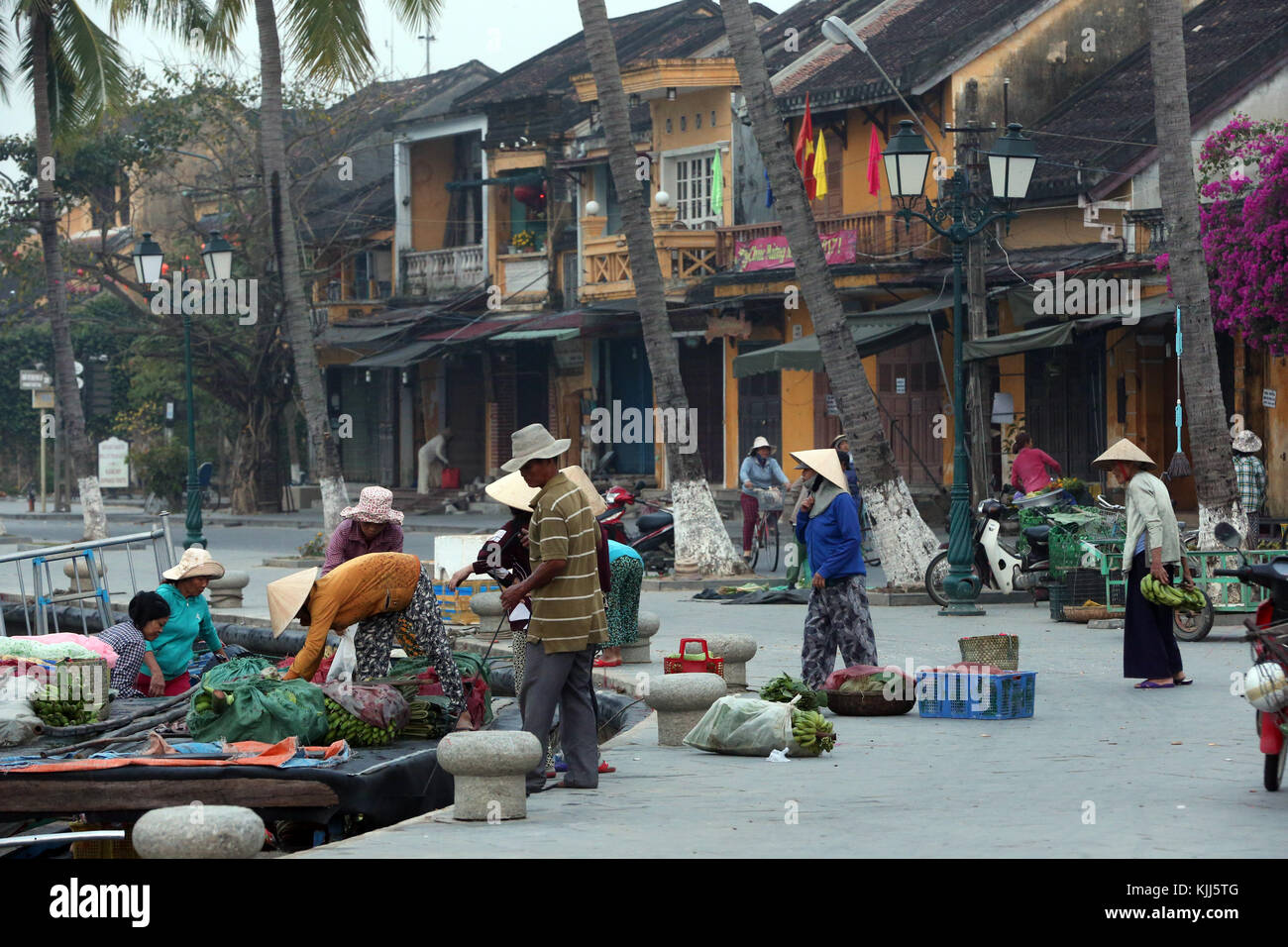 Le donne nel cappello conico con merci per la vendita sul mercato dei prodotti freschi. Hoi An. Il Vietnam. Foto Stock