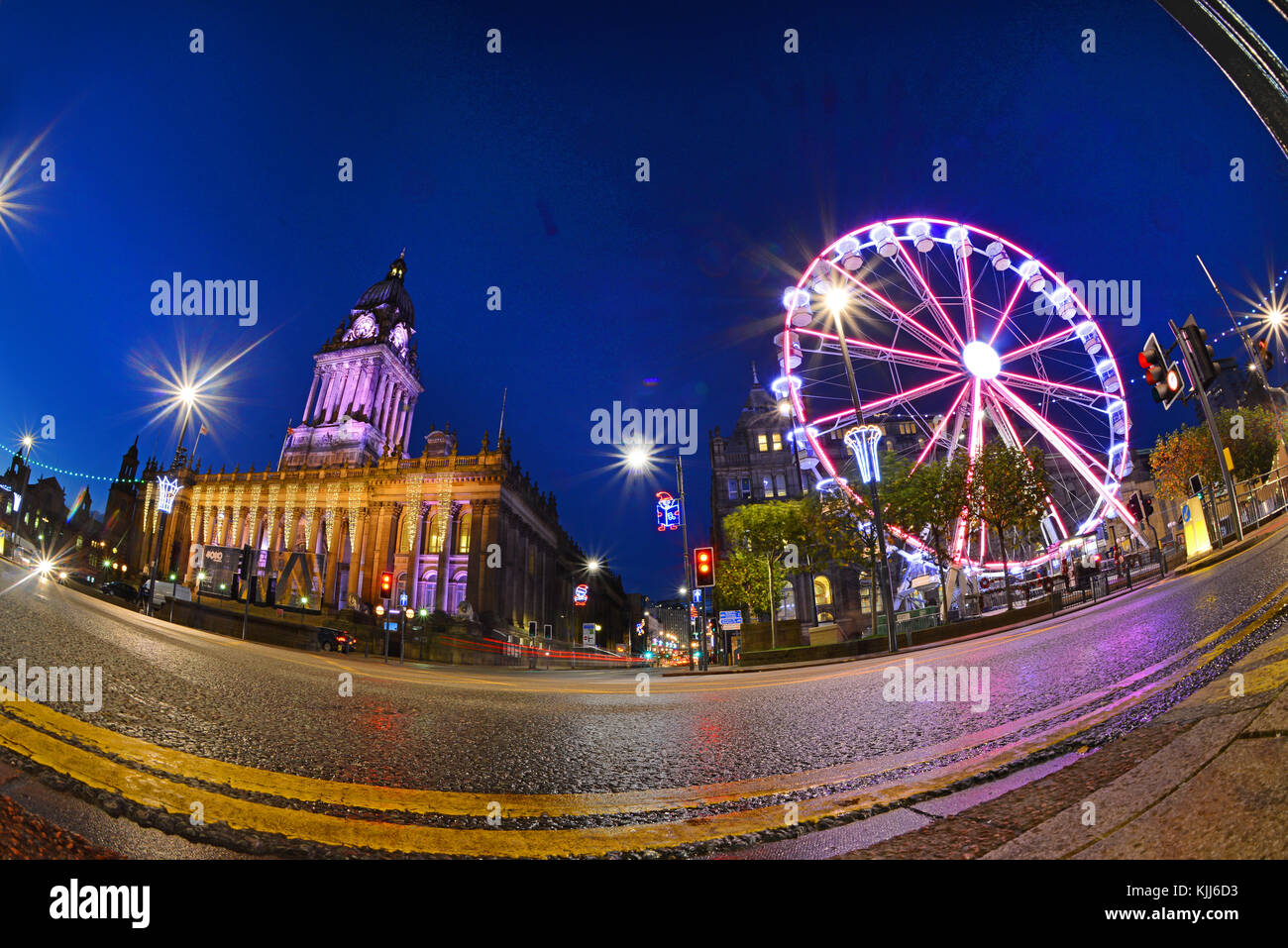 Il traffico che passa luna park e le luci di Natale da leeds town hall al crepuscolo Yorkshire Regno Unito Foto Stock