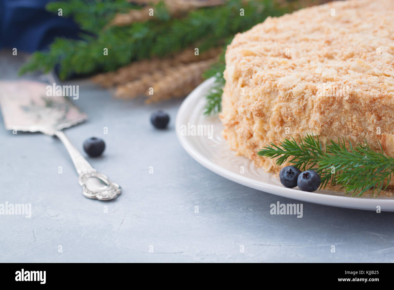 Round multi-layered Napoleone torta con crema pasticcera, su un azzurro sfondo tabella. il fuoco selettivo. cucina russa. Foto Stock