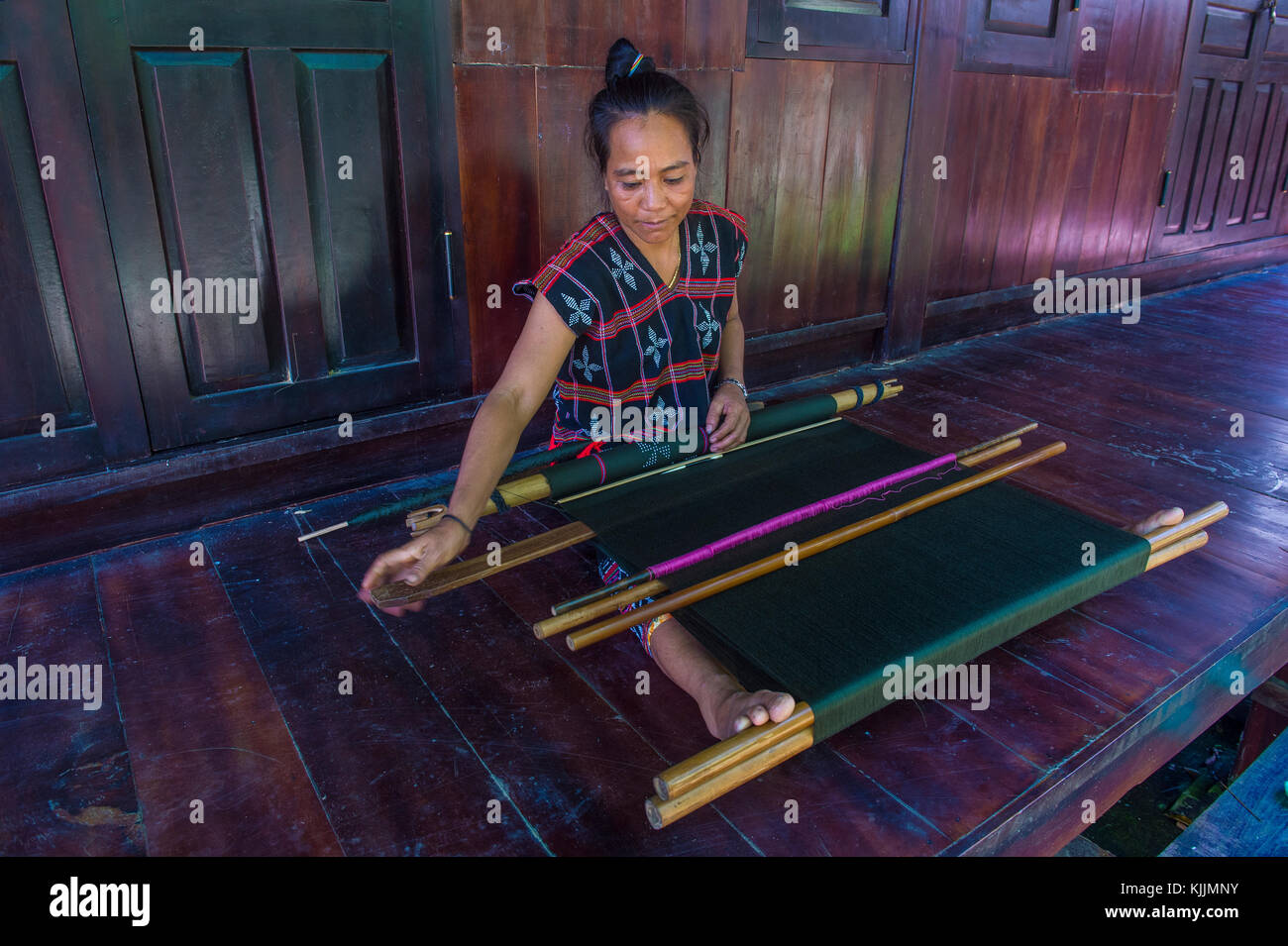 Una donna dalla minoranza Cotu si intreccia con una fascetta telaio in Quang Nam Vietnam Foto Stock