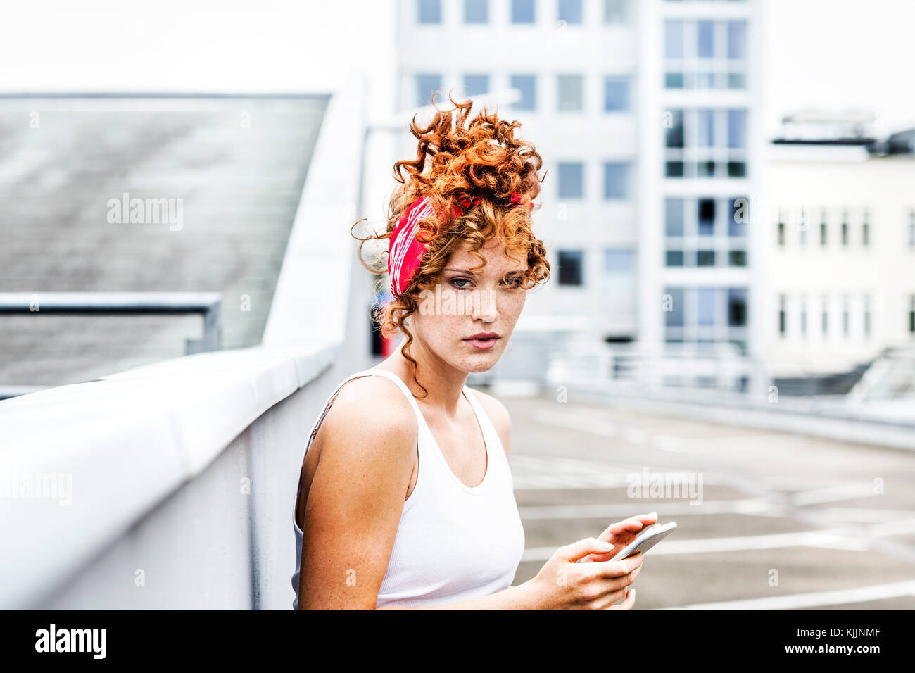 Ritratto di donna redheaded azienda telefono cellulare Foto Stock