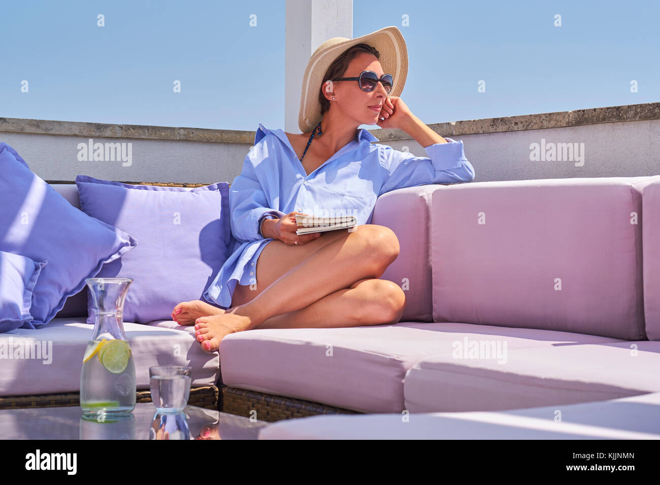 Donna con prenota relax su sun deck Foto Stock