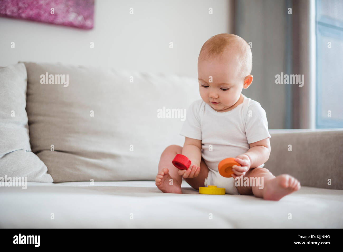 Baby girl giocando sul lettino a casa Foto Stock