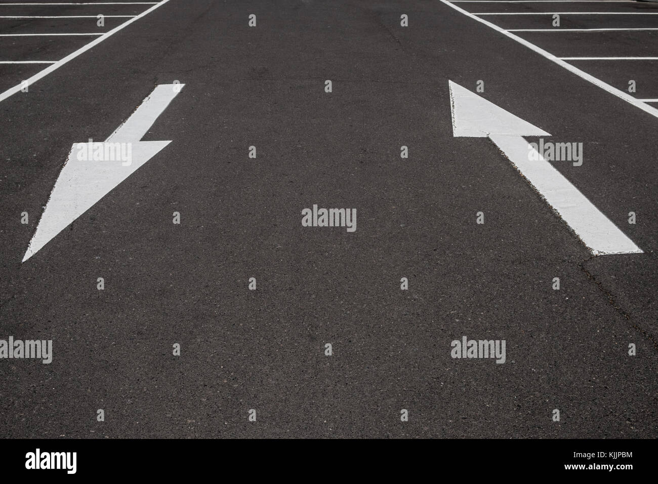 Frecce bianche su asfalto nero lo sfondo su strada Foto Stock