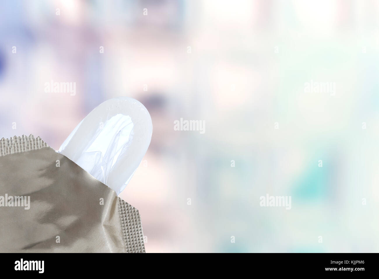 Il preservativo close-up isolato contraccettivo. in uscita dal pack su sfondo blury Foto Stock