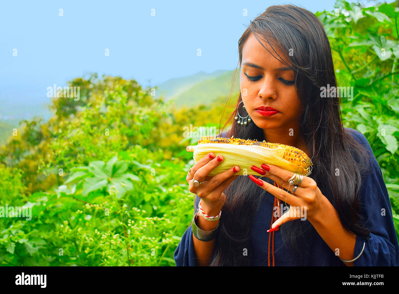 Ragazza indiana che mangia Corn nar Mountain, Pune, Maharashtra. Foto Stock