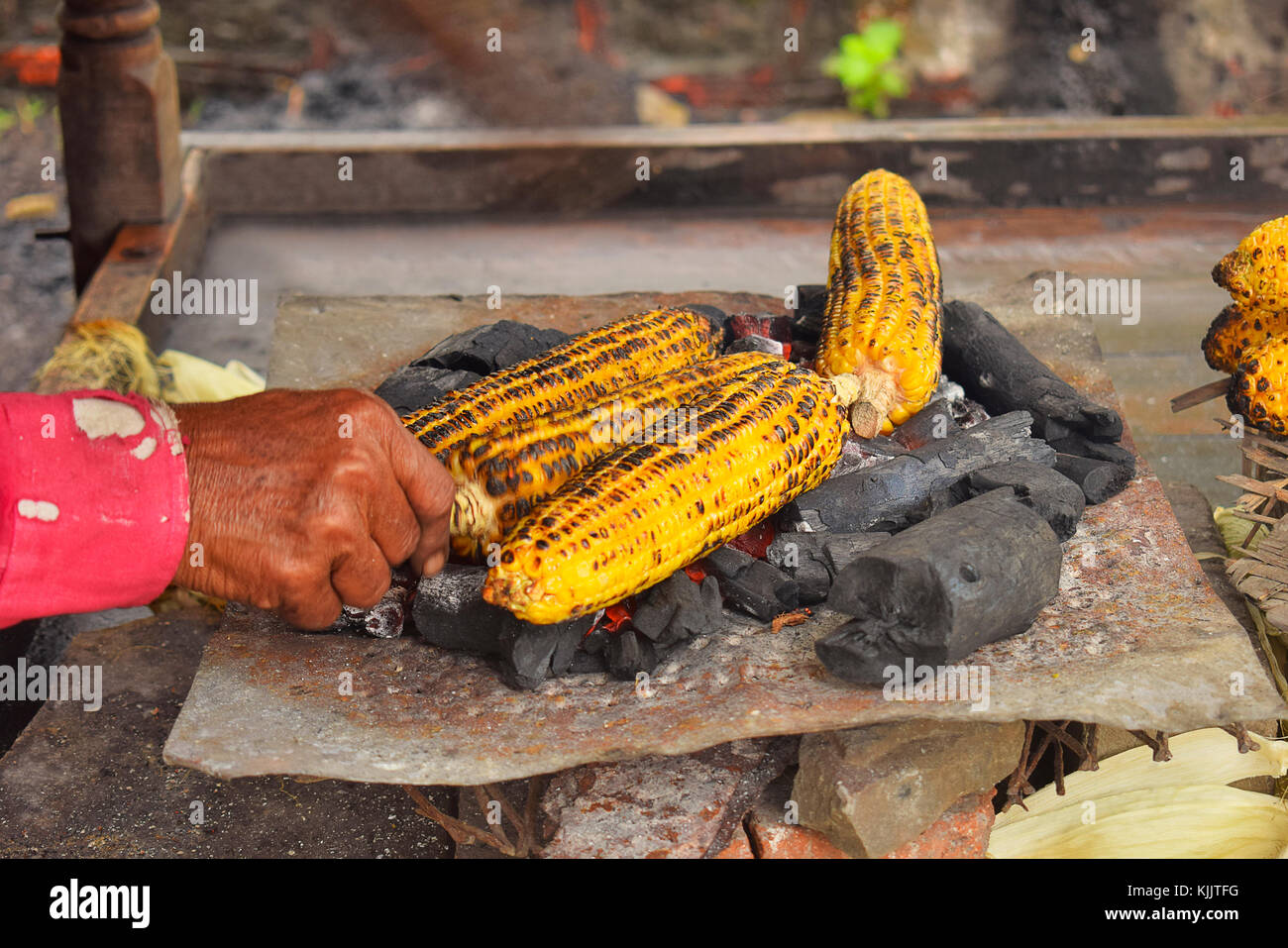 Il mais viene tostato sul carbone, Pune, Maharashtra. Foto Stock
