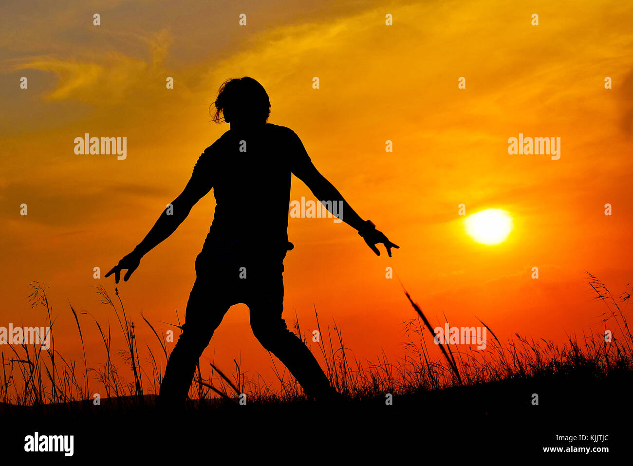 Silhouette di una ballerina Hip Hop che posa vicino alla montagna al tramonto, Pune, Maharashtra. Foto Stock