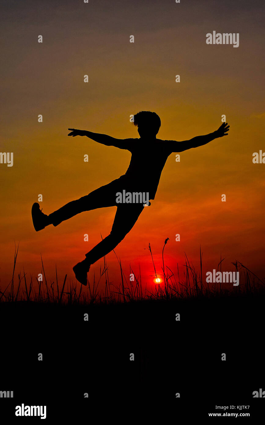 Silhouette di una ballerina Hip Hop che posa vicino alla montagna al tramonto, Pune, Maharashtra. Foto Stock