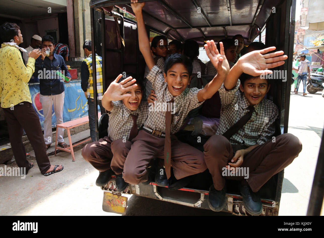 Ajmer scolari sventolare da un veicolo. India. Foto Stock