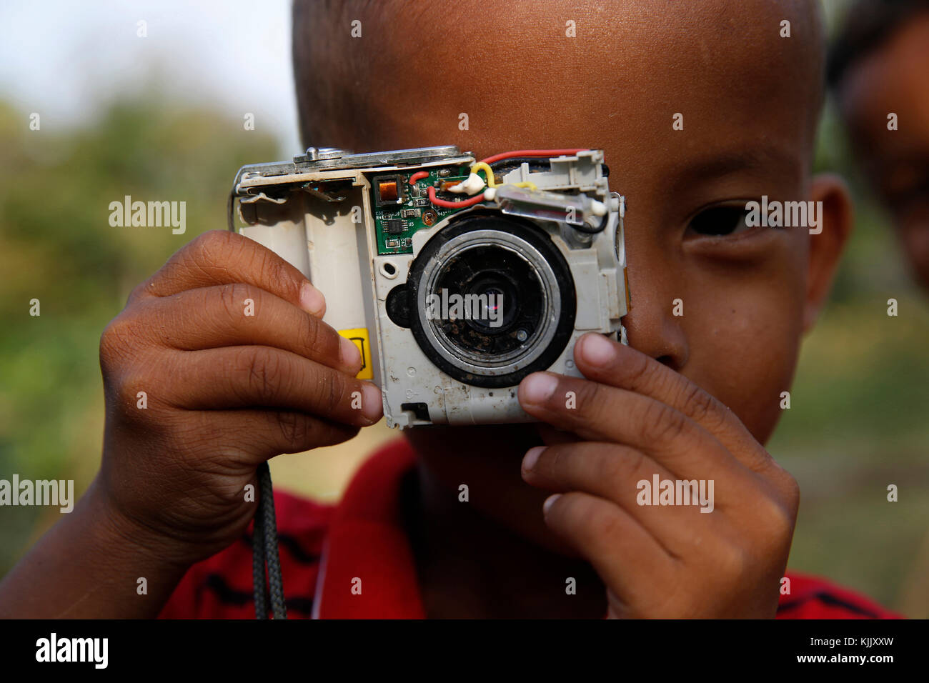 Ragazzo Khmer tenendo un giocattolo telecamera. Battambang. Cambogia. Foto Stock