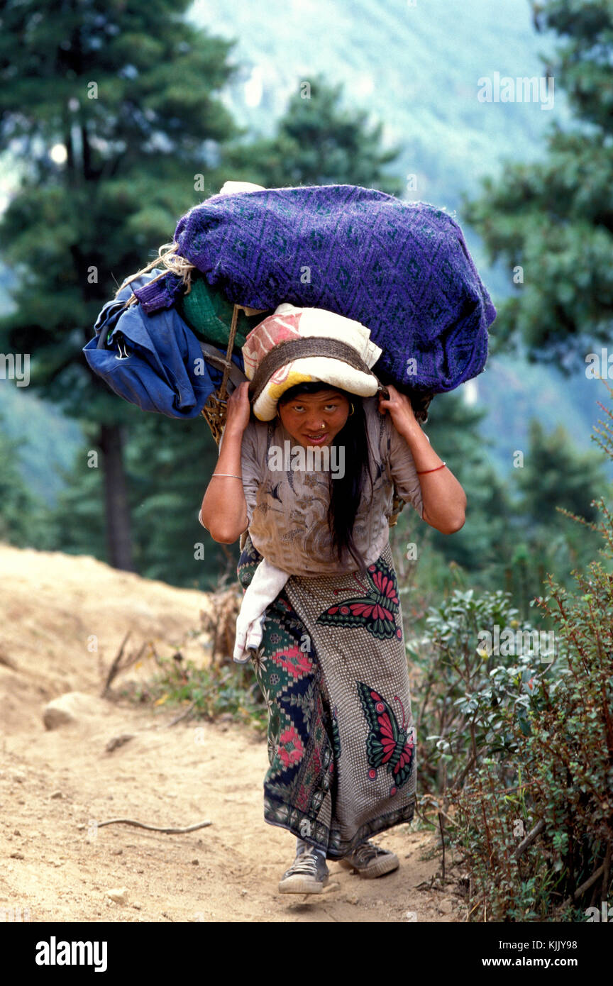 Sherpa sacchetti porta su di un percorso di trekking. Il Nepal. Foto Stock