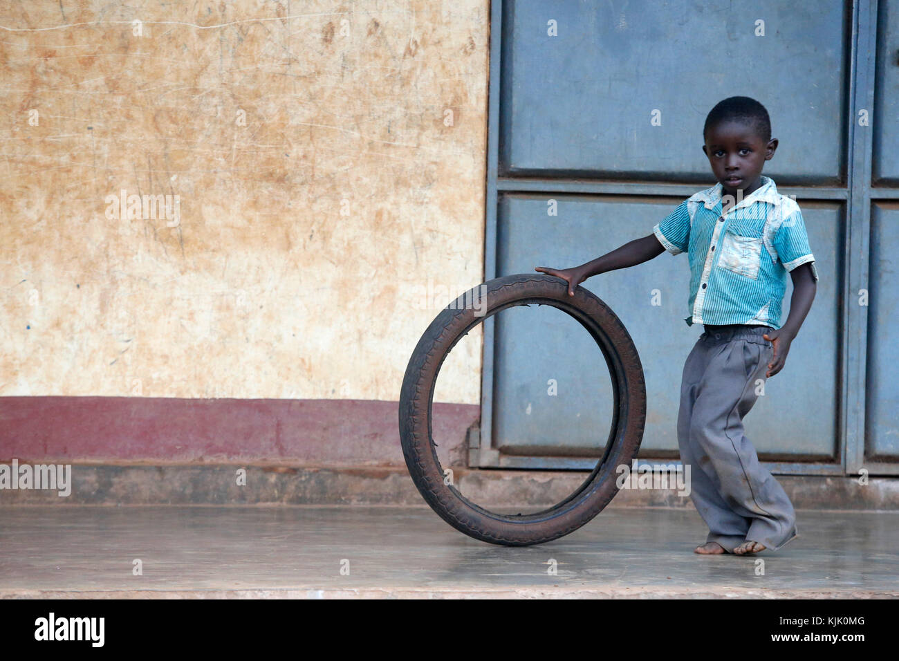 Bambino ugandese giocando con un pneumatico. Uganda Foto Stock