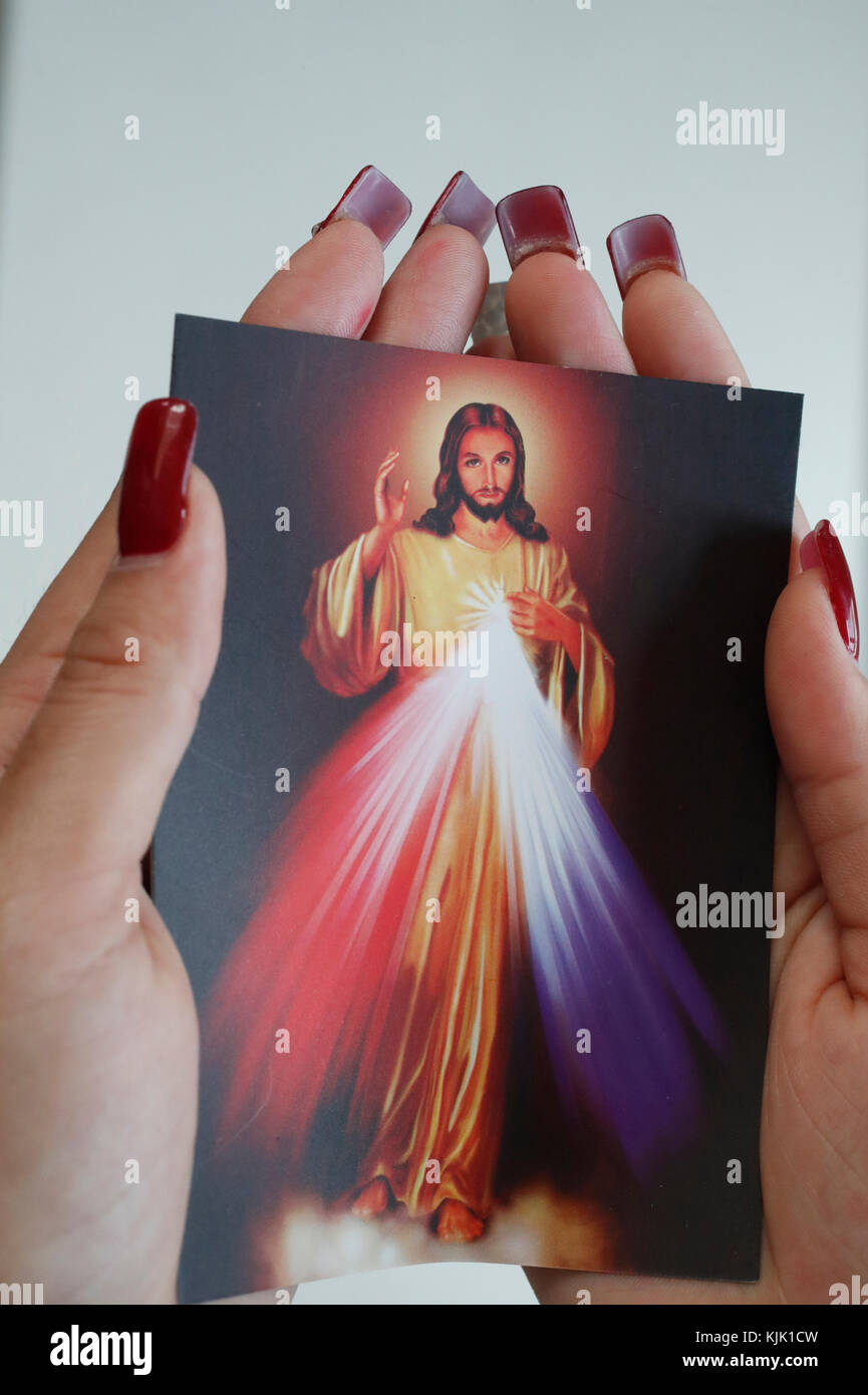 Donna cattolica pregando con la sacra immagine di Gesù. Ho Chi Minh City. Il Vietnam. Foto Stock