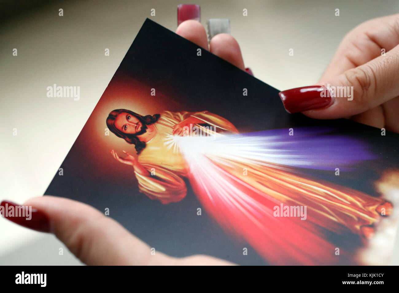 Donna cattolica pregando con la sacra immagine di Gesù. Ho Chi Minh City. Il Vietnam. Foto Stock