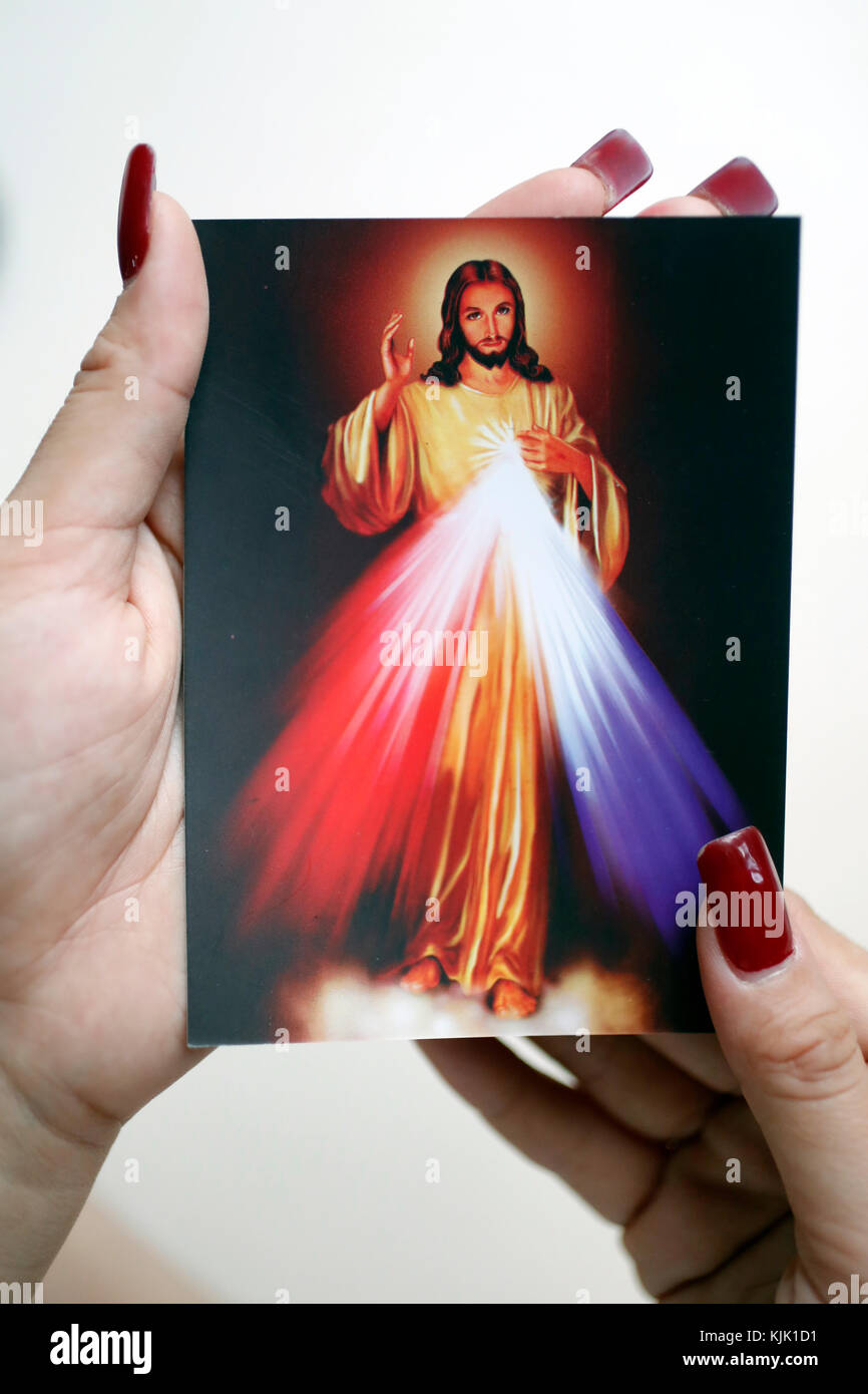 Donna cattolica pregando con la sacra immagine di Gesù. Ho Chi Minh City. Il Vietnam. Foto Stock