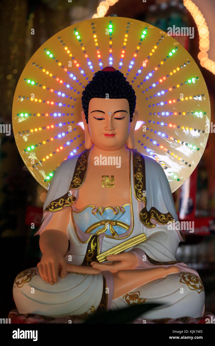 Chua Vinh Nghiem pagoda buddista. Statua del Buddha con luce al neon in-bhumisparsha mudra postura (chiamando la terra ad essere suo testimone). Ho Chi Minh Cit Foto Stock