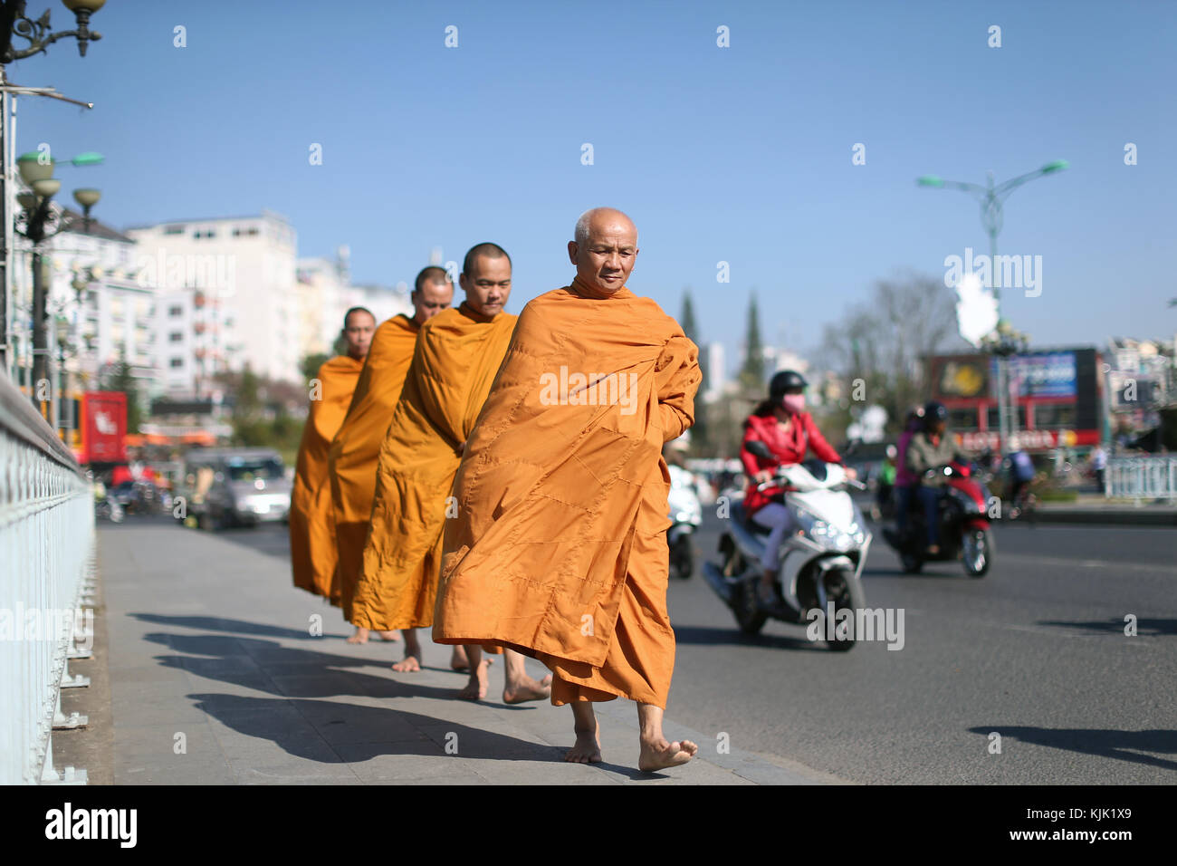 I monaci camminare per la strada raccogliendo elemosine. Dalat. Il Vietnam. Foto Stock