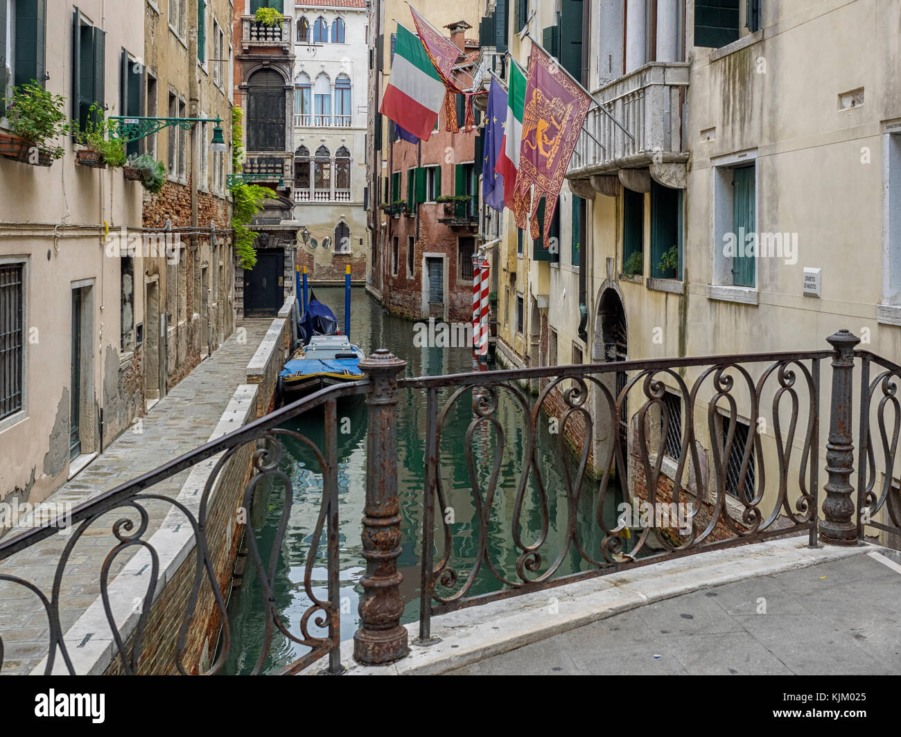 VENEZIA, ITALIA - 12 SETTEMBRE 2017: Bandiere che volano da case che si affacciano sul piccolo canale Foto Stock