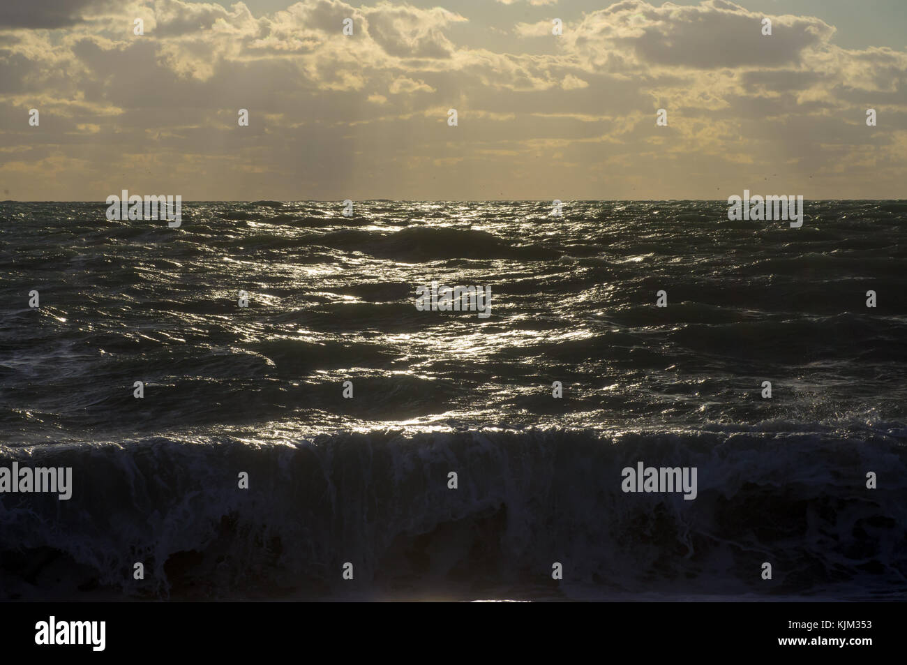 Tempesta in mare i raggi del sole al tramonto, l'onda batte contro la riva Foto Stock