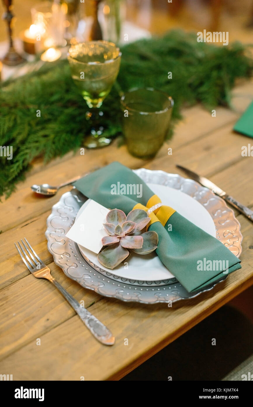 Progettazione, romanticismo, dating concetto. Impostazione tabella per una romantica cena per gli amanti creato in stile vintage con argenti e decorate fresco rami di conifere posto al centro del tavolo Foto Stock