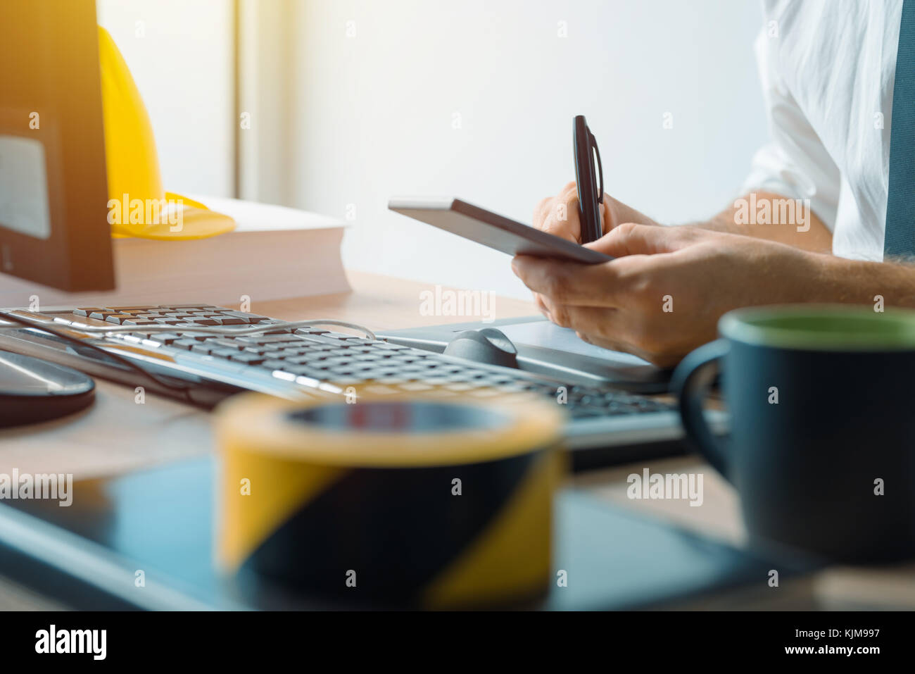 Ingegnere civile utilizza lo smartphone in ufficio durante la costruzione del settore per lo sviluppo del progetto Foto Stock