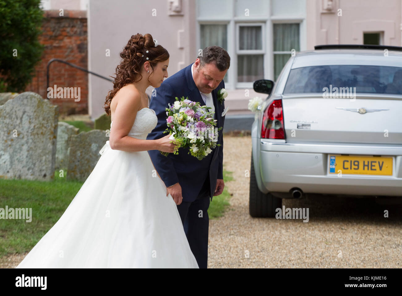 Sposa in bianco tradizionale con il padre che sta per entrare in chiesa Foto Stock